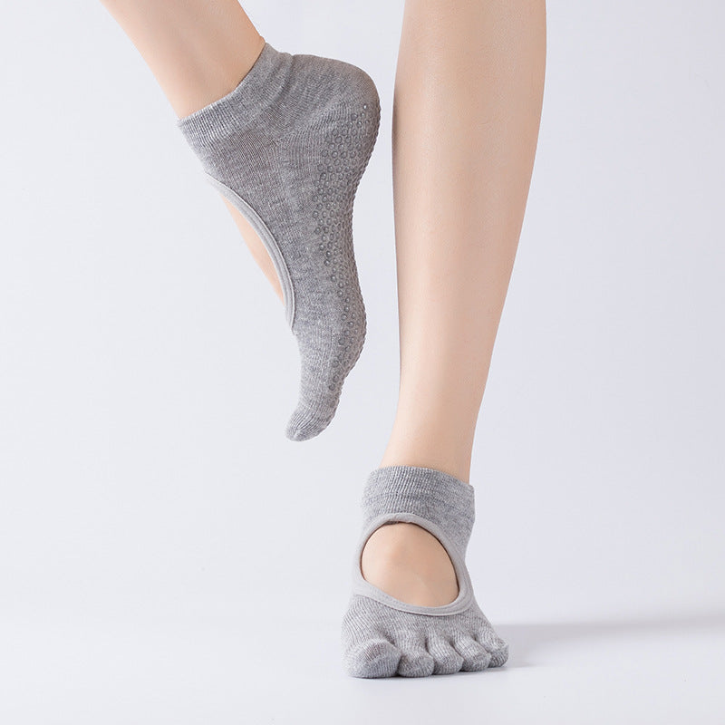 Gray toe-separated socks worn on feet against a light gray background