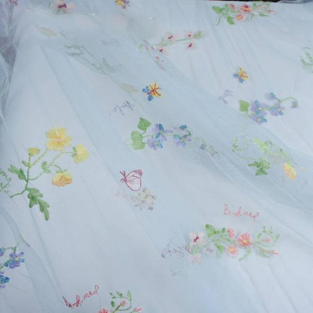 Embroidered fabric with floral patterns on a light blue background