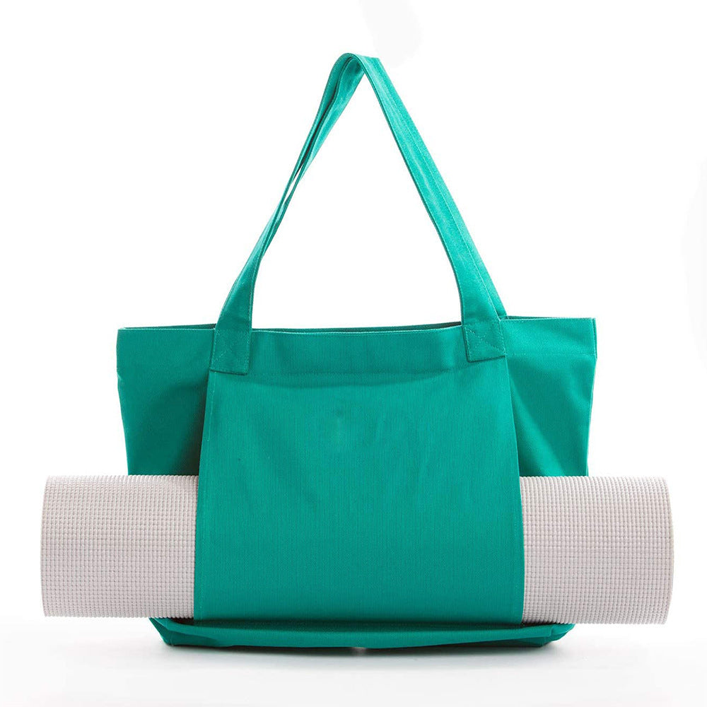 Green tote bag with a yoga mat inside on a white background