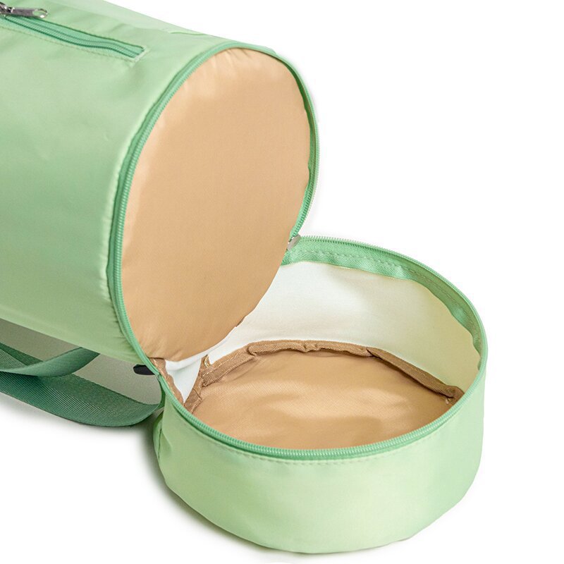 Green travel bag with beige interior showing a folded beige garment inside.