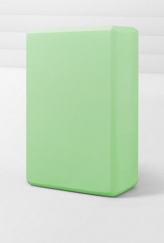 Green yoga block on a white background