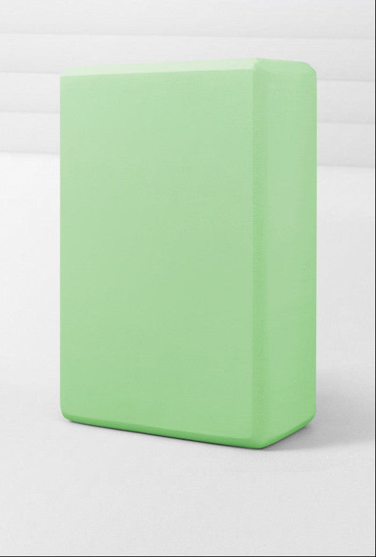 Green yoga block on a white background