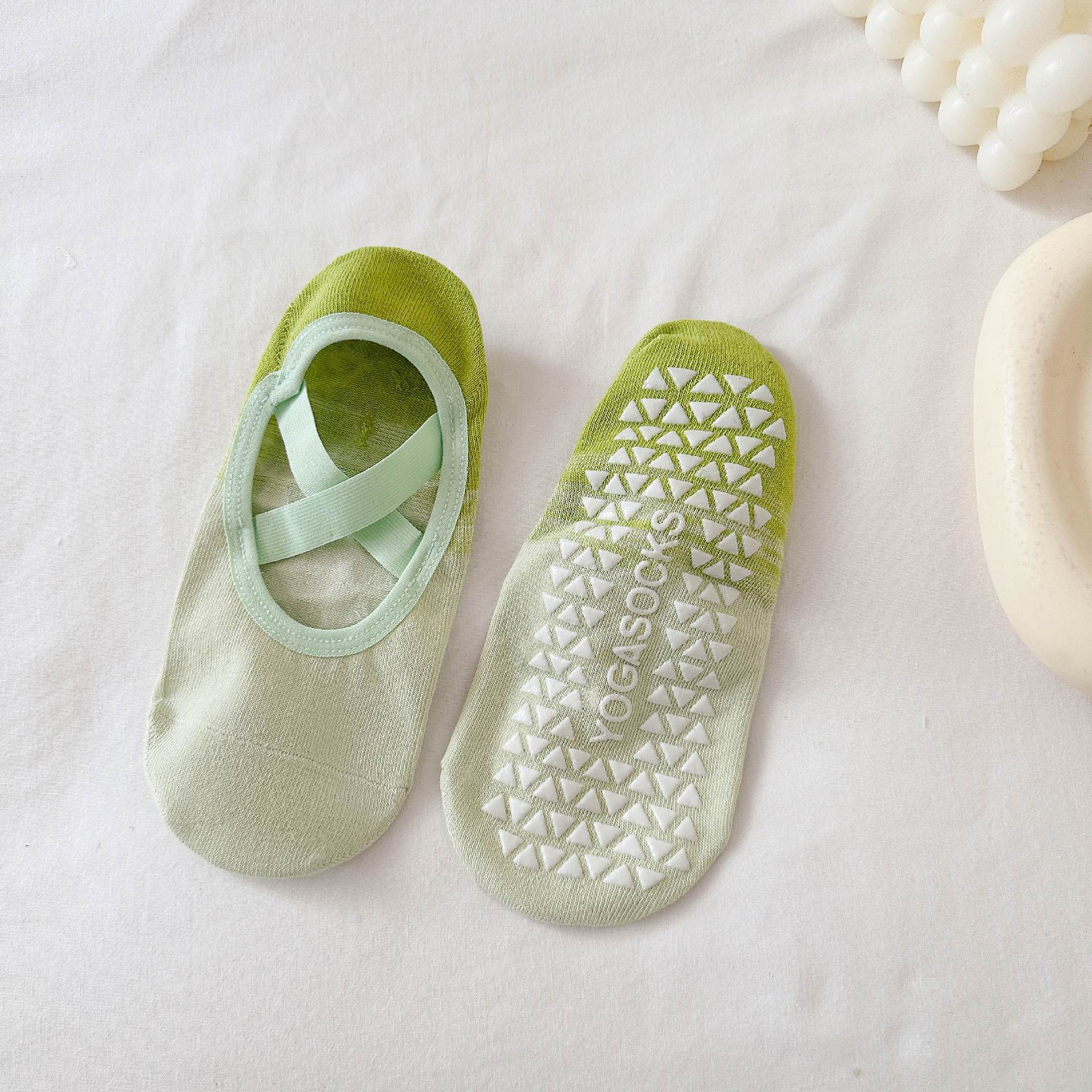 Green yoga socks with a textured sole on a light background