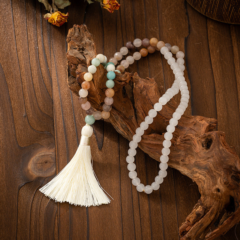 Jewelry set with beads and tassel on a wooden background