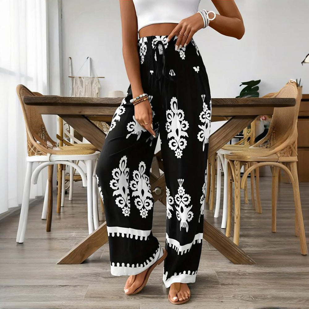 Person wearing black pants with white patterns in a dining room setting