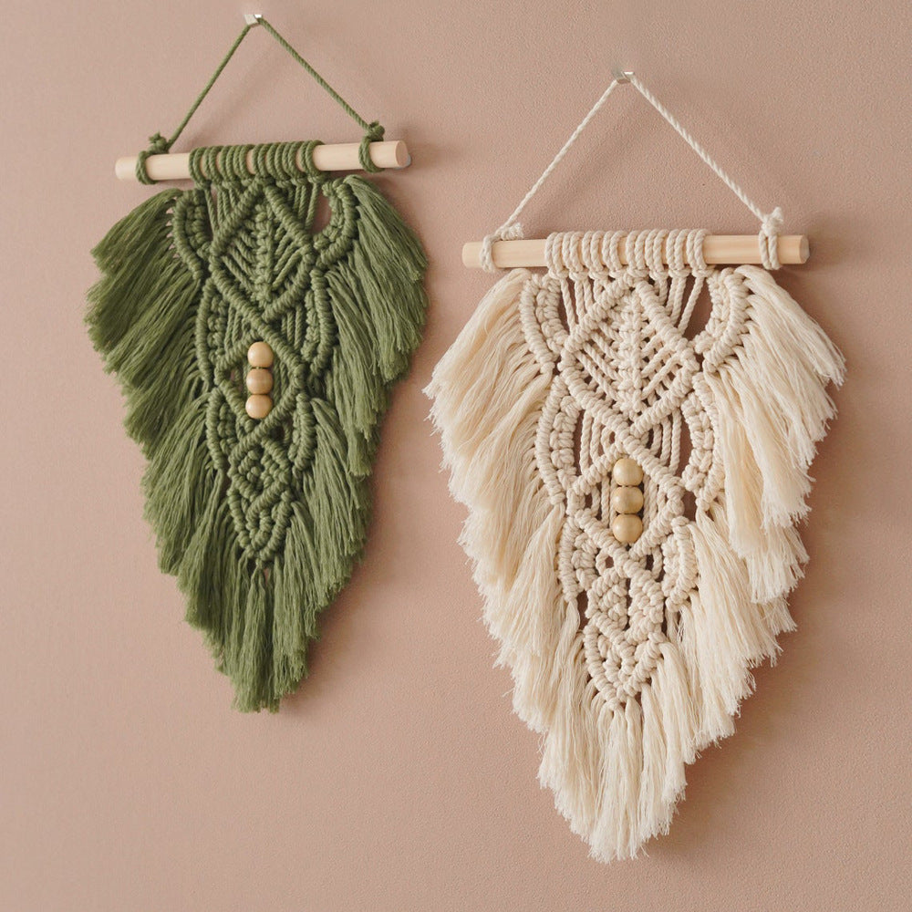 Two macrame wall hangings, one green and one beige, on a beige background.
