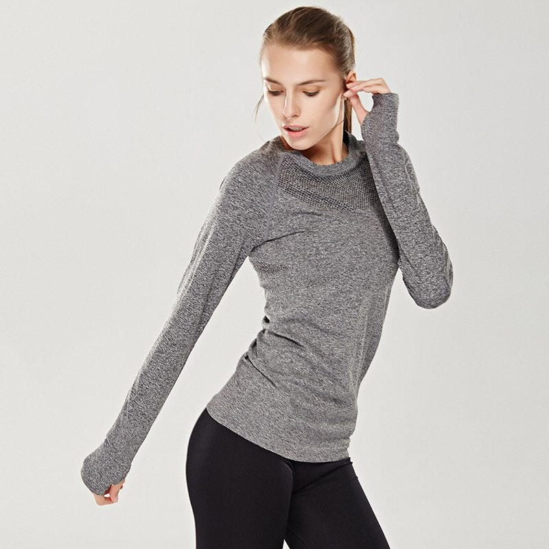 Woman wearing a gray long-sleeve top on a light gray background
