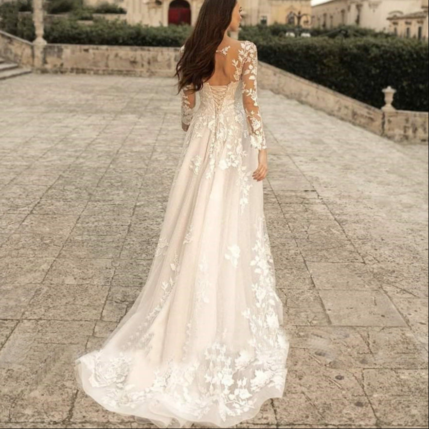 Woman in a white floral wedding dress walking on a stone path with classical architecture in the background