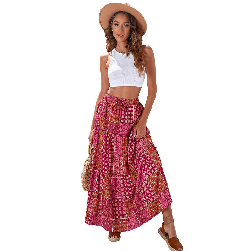 Woman wearing a white top and pink patterned skirt with a hat on a white background