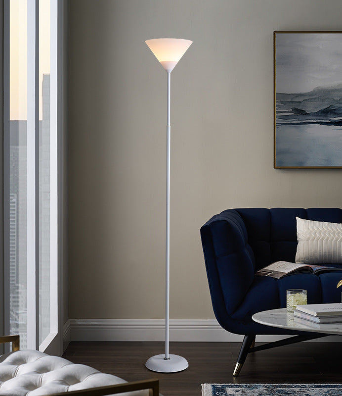 Modern living room with a floor lamp, blue sofa, and artwork on the wall.