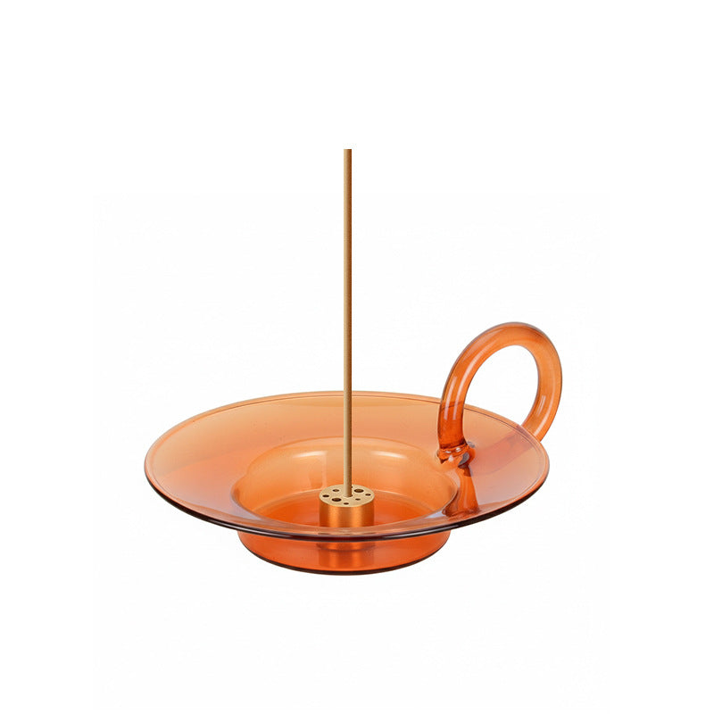 Orange glass bowl with a handle and central rod on a white background
