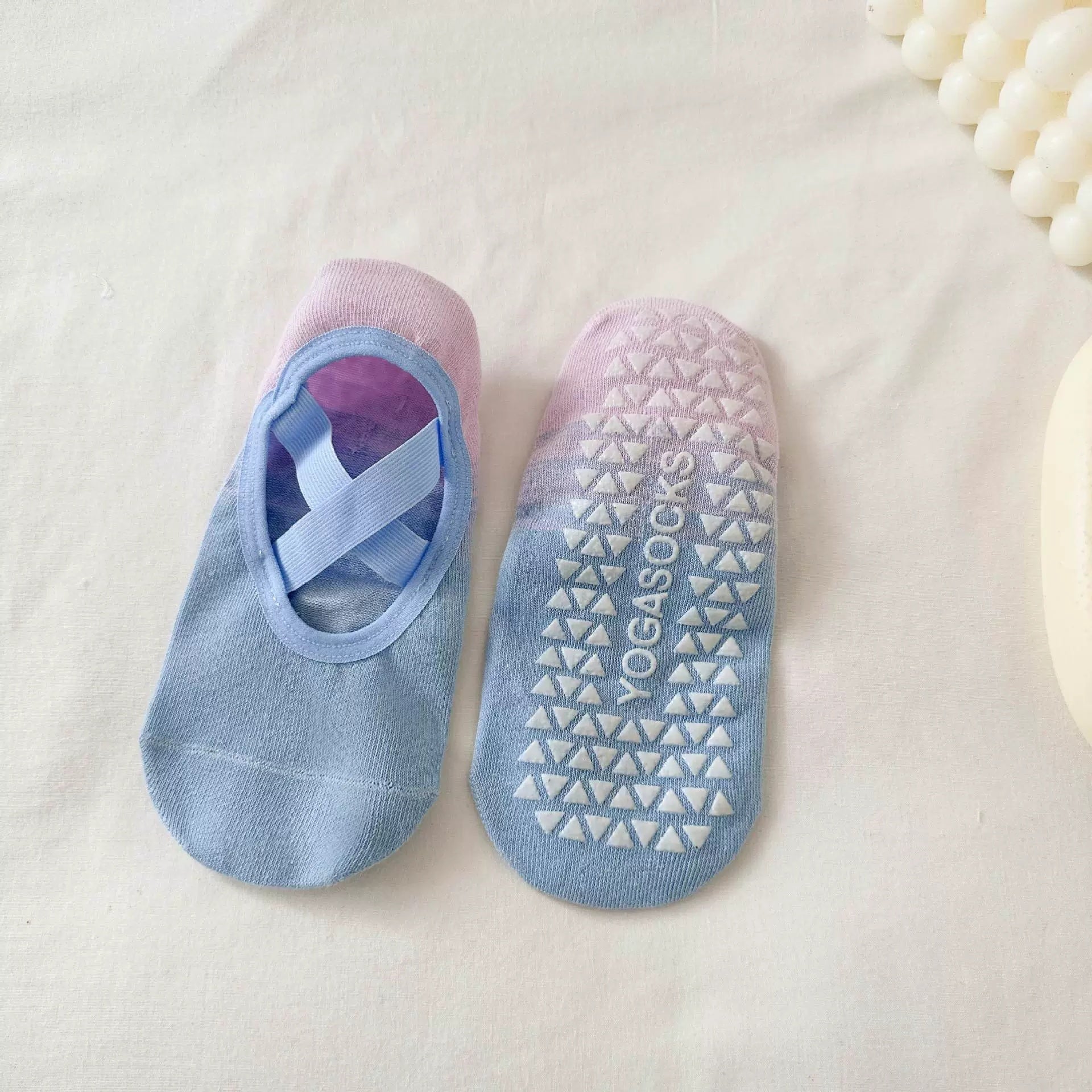 Pair of blue and pink yoga socks with a visible brand logo on a light background