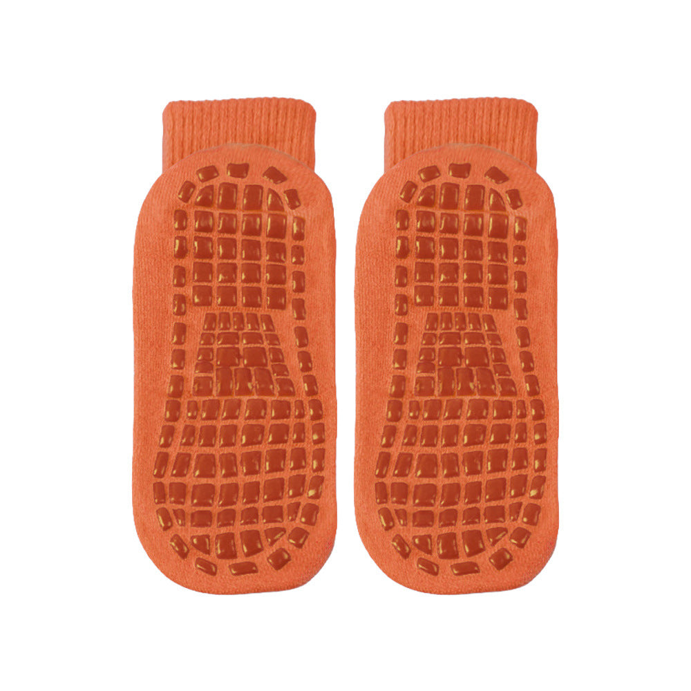 Pair of orange bath mats with textured surface on a white background