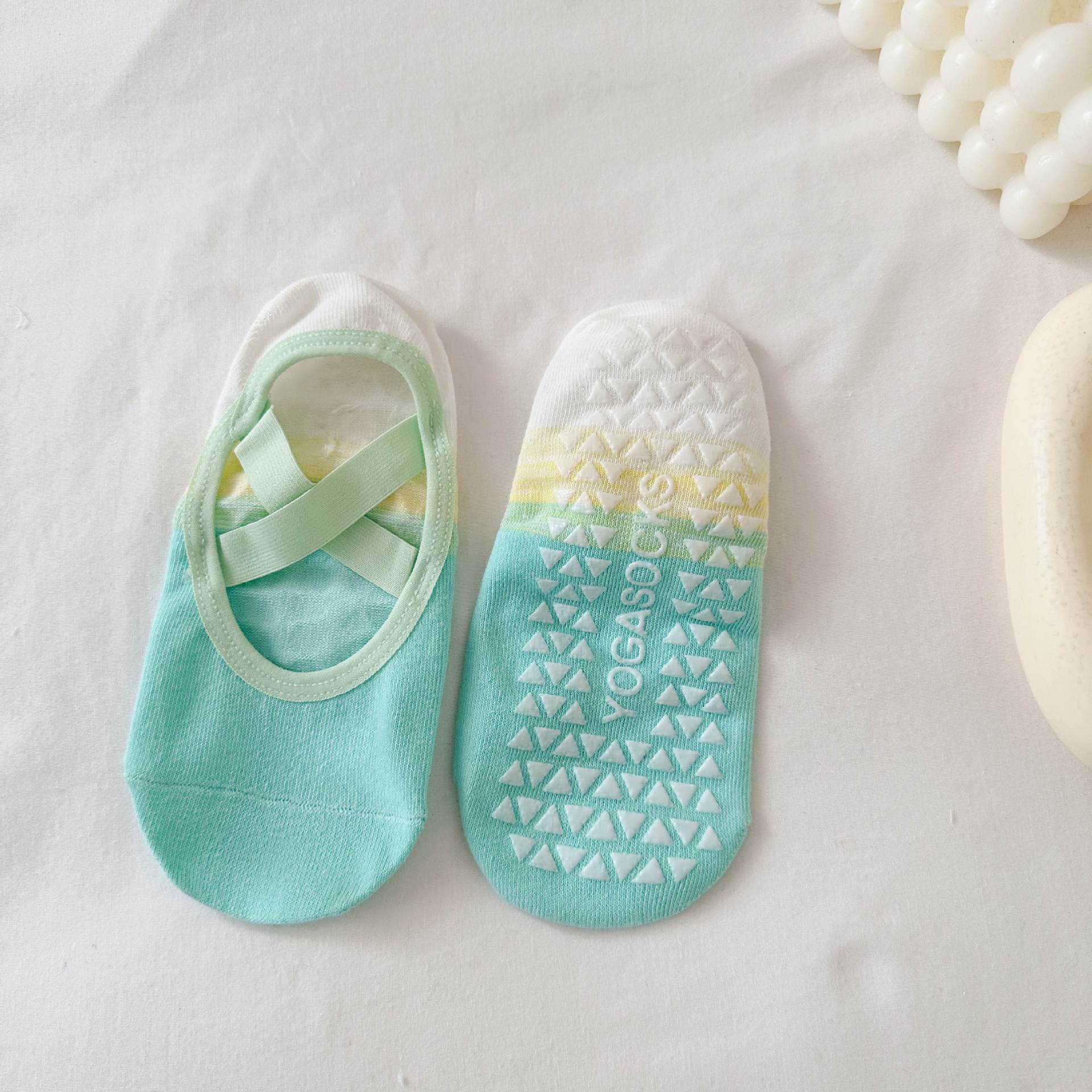 Pair of turquoise socks with a patterned sole on a light background