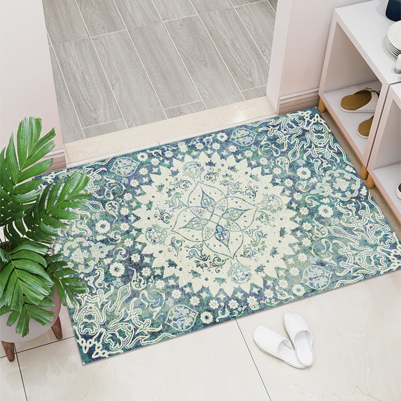 Floral patterned rug on a tiled floor with a plant and shoes in the foreground