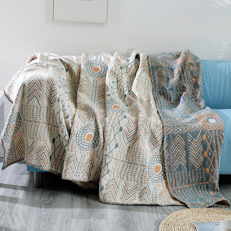 Patterned blanket draped over a sofa in a living room setting