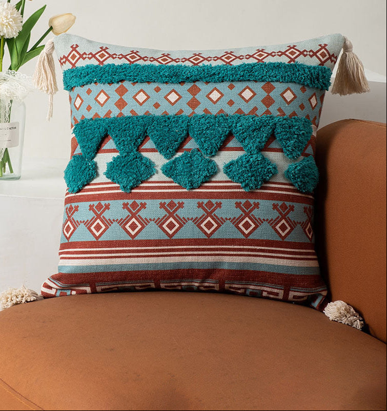 Decorative pillow with geometric pattern and tassels on a brown couch