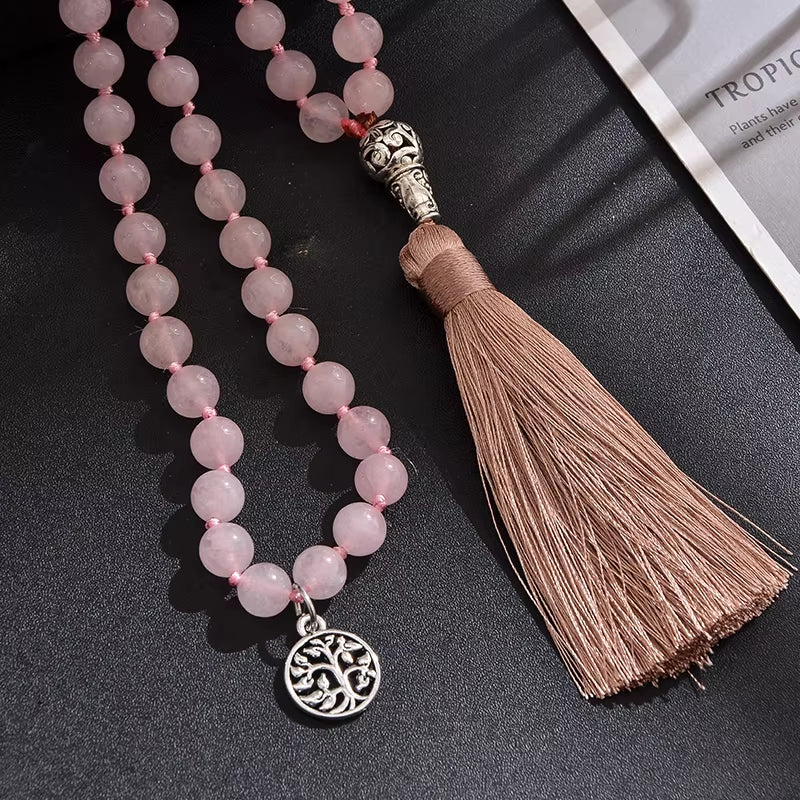 Necklace with pink beads and tassel on a dark surface