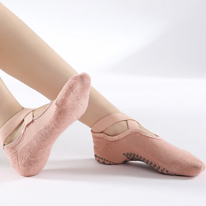 Pink ballet shoes worn with beige tights on a white background