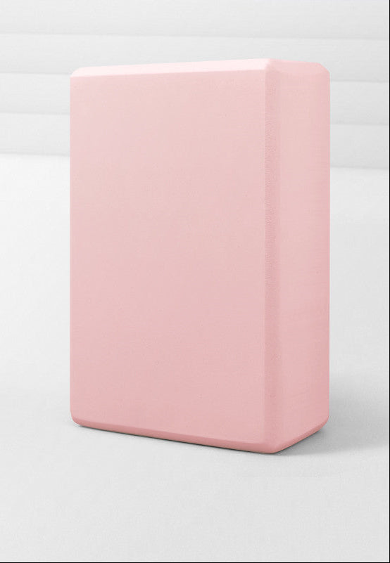 Pink yoga block on a white background