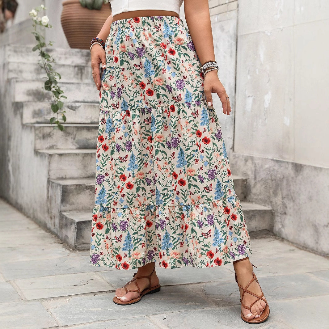 Person wearing a floral skirt standing on a stone path with steps in the background.