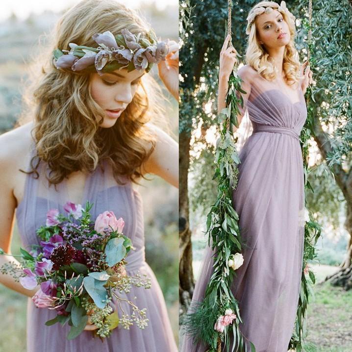 Woman in a lavender dress with floral headpiece and bouquet, standing outdoors.