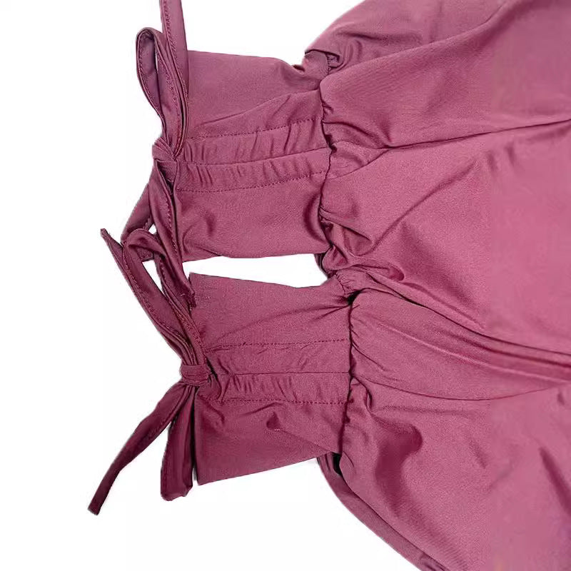 Close-up of a pink outfit with tied sleeves on a white background