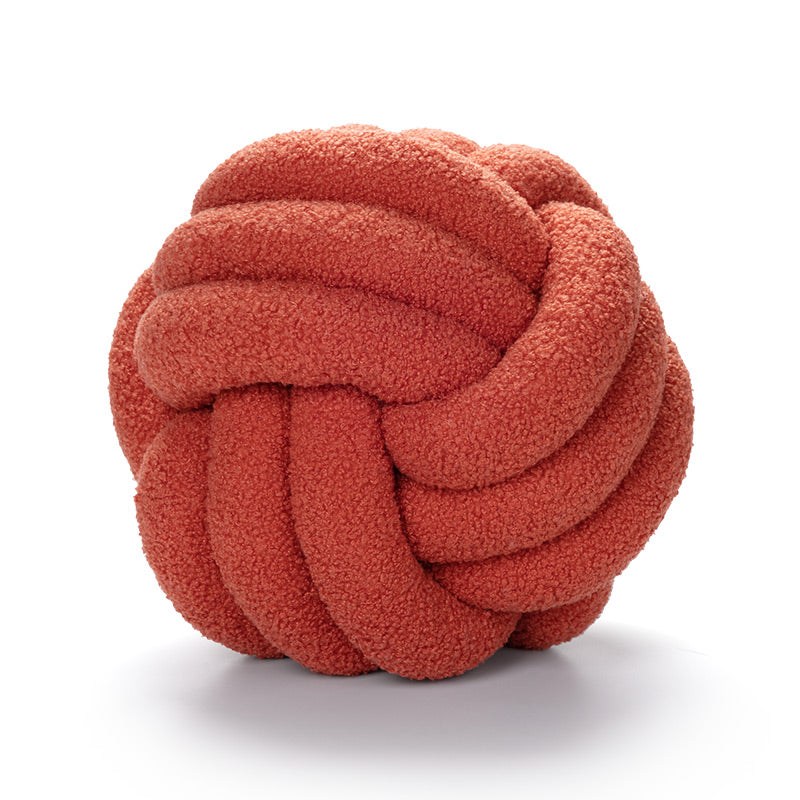 Red knotted ball toy on a white background