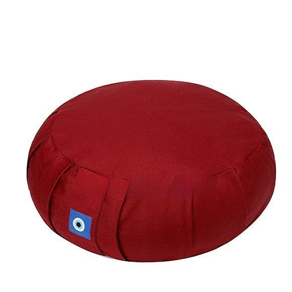 Red meditation cushion with a blue patch on a white background