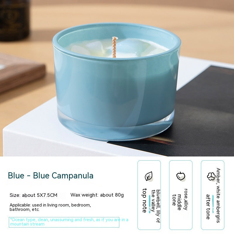 Blue candle with a white wick on a wooden surface