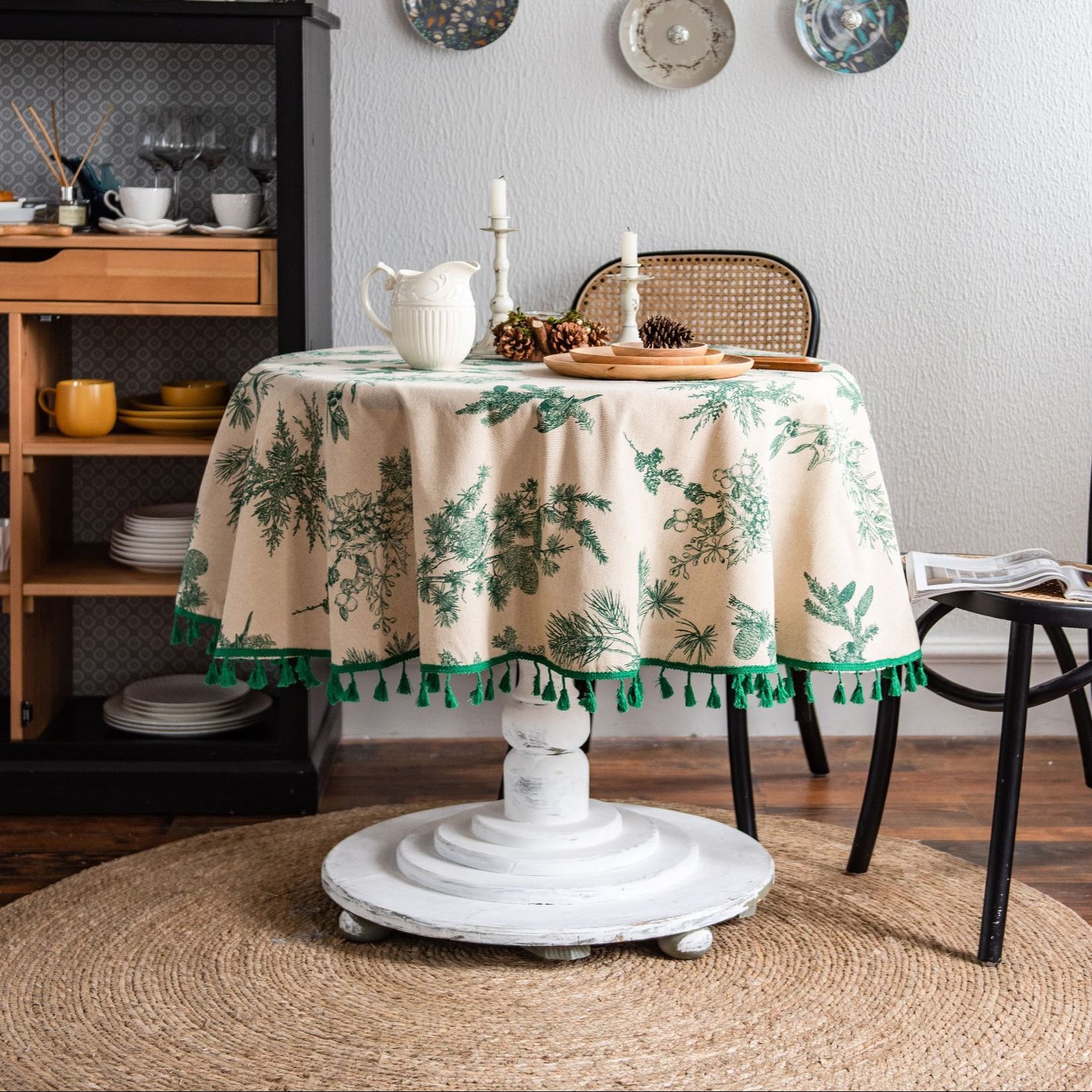 Round table with a decorative tablecloth in a cozy dining room setting.