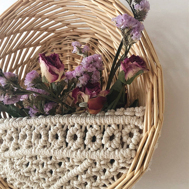 Woven basket with macrame detail and purple flowers on a neutral background