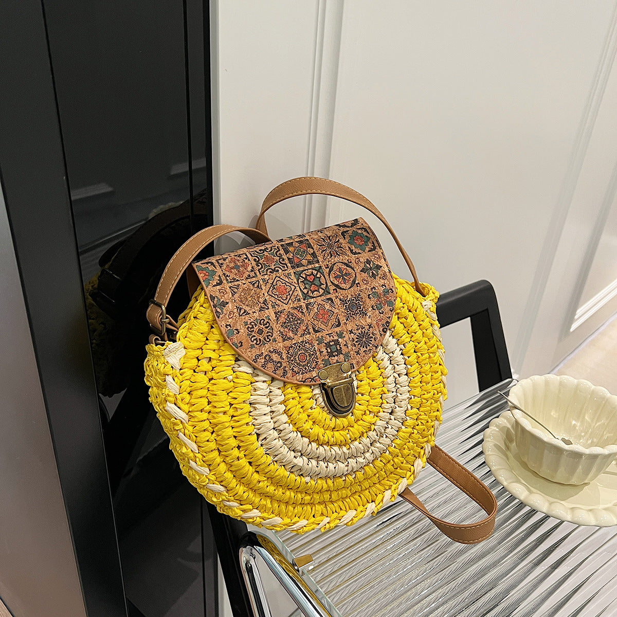 Yellow and beige woven handbag with a patterned flap on a chair