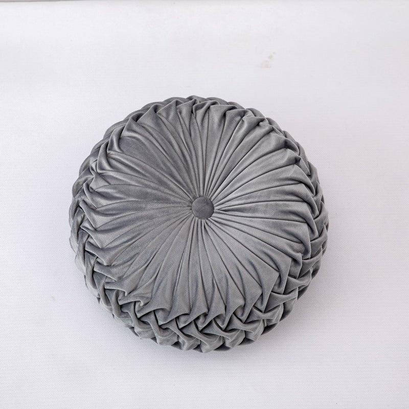 Round gray pleated cushion on a white background