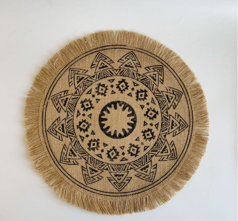 Round jute mat with black geometric pattern on a white background