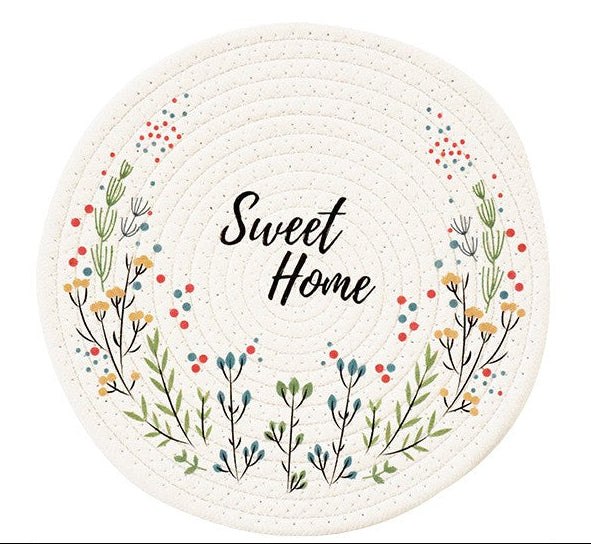 Round woven mat with floral design and 'Sweet Home' text on a white background