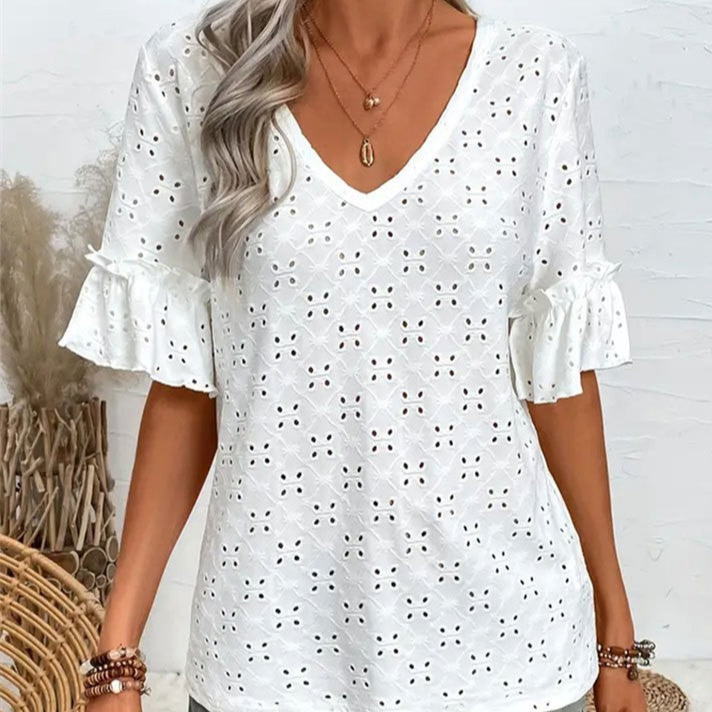 White eyelet blouse worn by a person with a neutral background