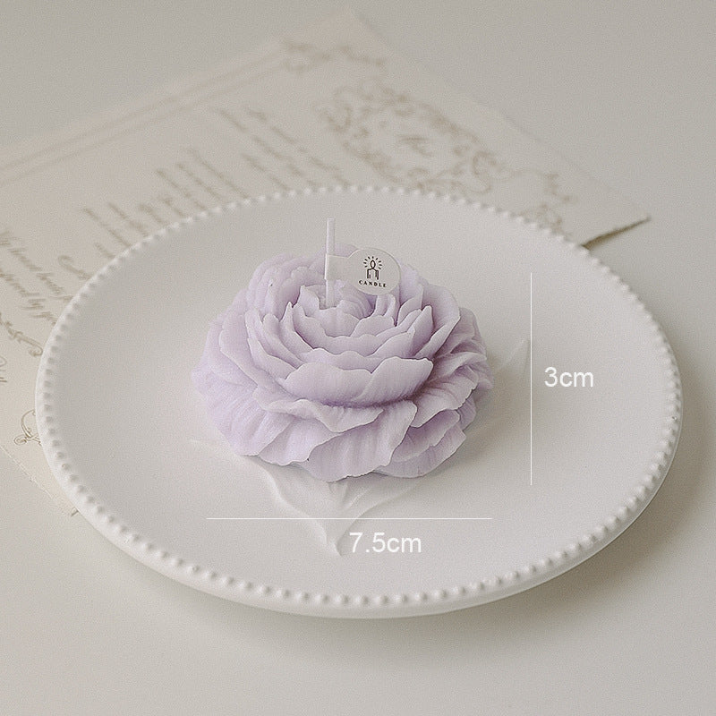 Purple flower candle on a white plate with measurements indicated