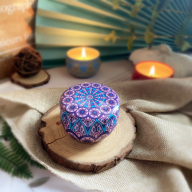 Decorative purple and blue patterned stone on a wooden slice with candles and fabric in the background