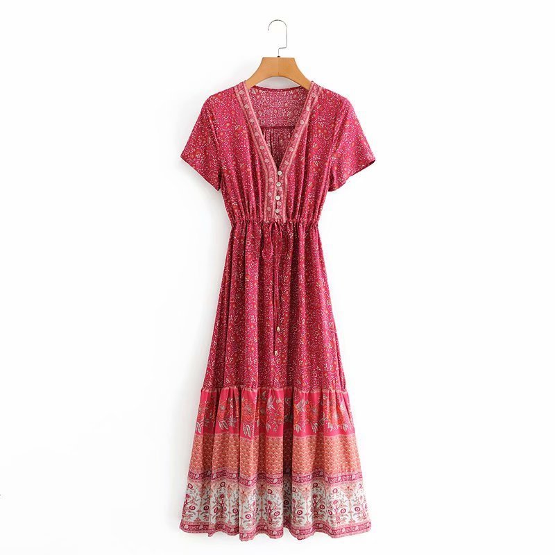 Red patterned dress on a hanger against a white background