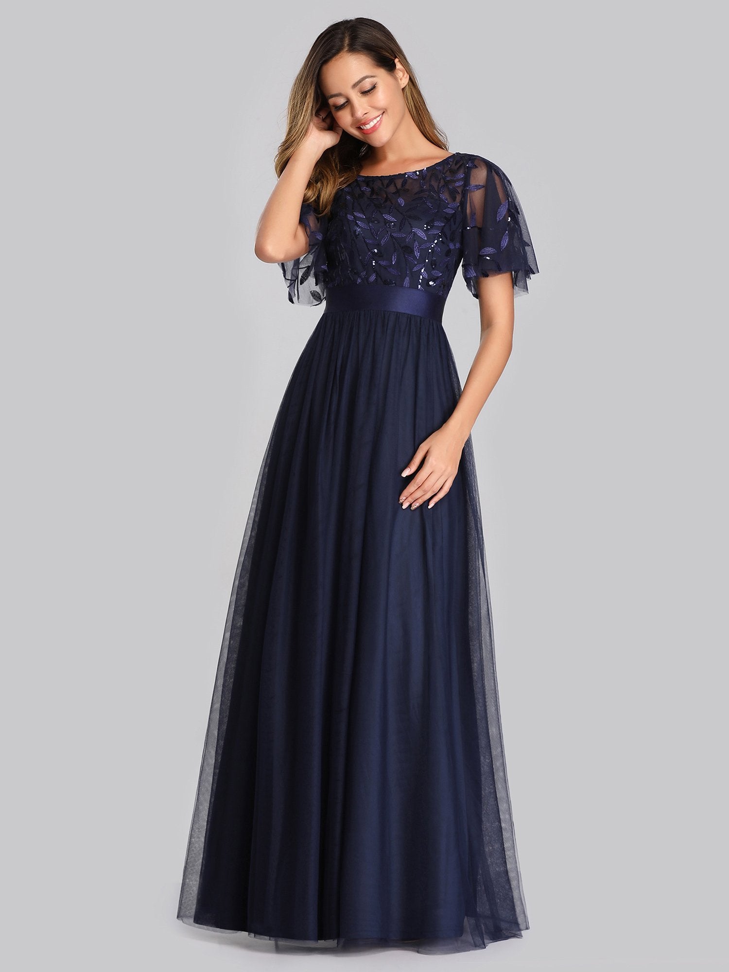 Navy blue evening gown with lace top on a gray background