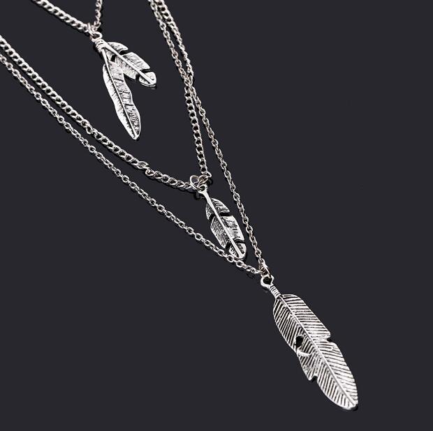 Silver feather necklace on a black background