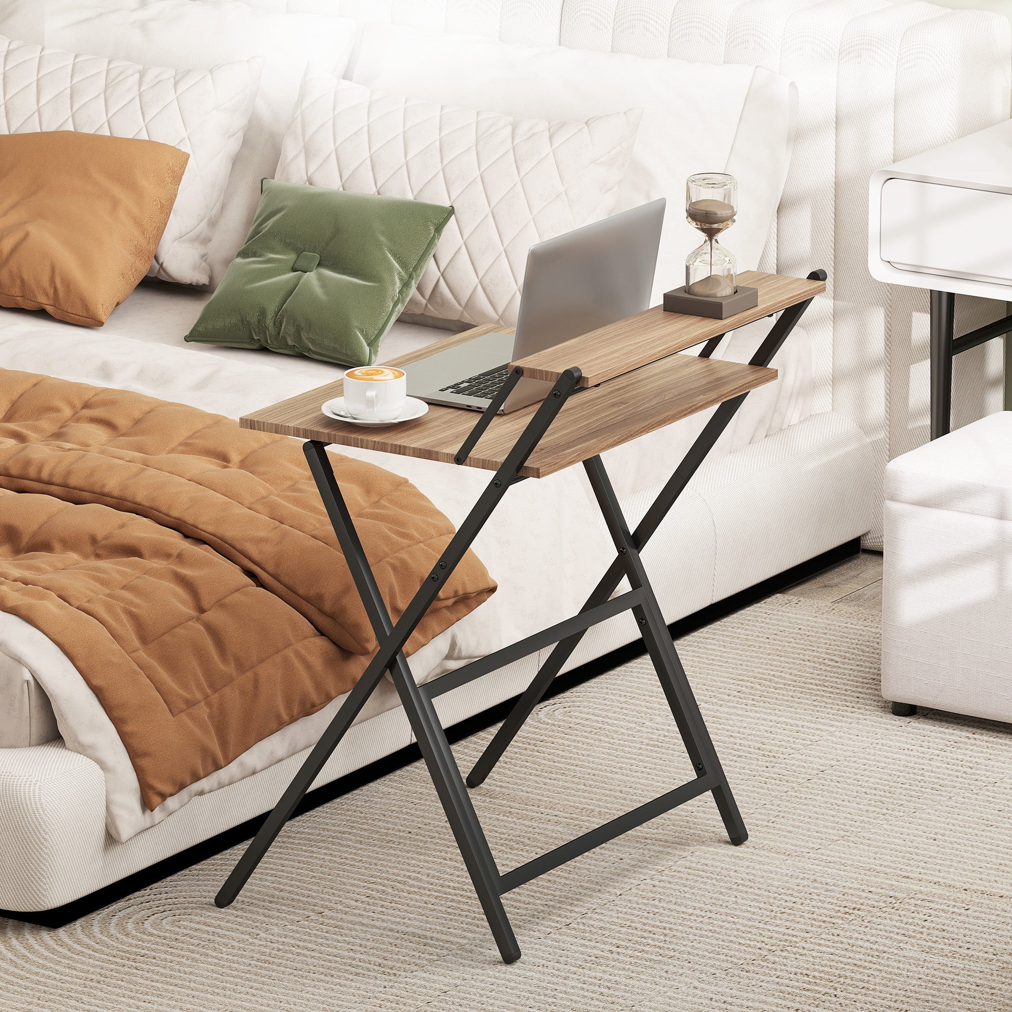 Wooden tray table on a bed with a laptop and cup, in a cozy bedroom setting.