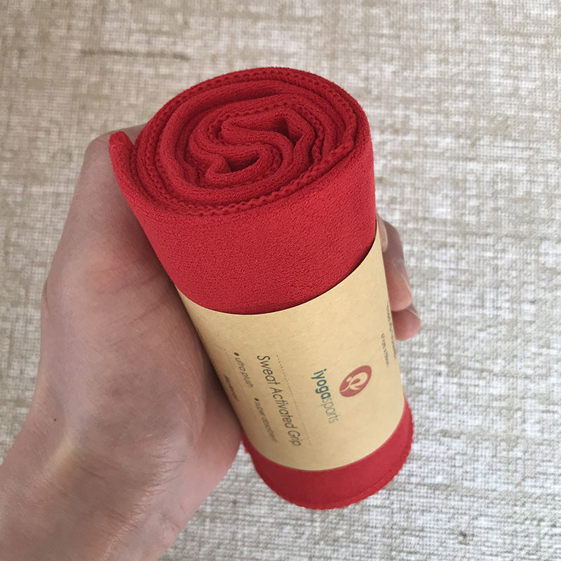 Red sweatband rolled up in a cardboard sleeve held by a hand on a textured surface