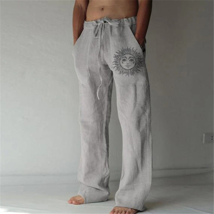 Gray sweatpants with a sun design on a plain background
