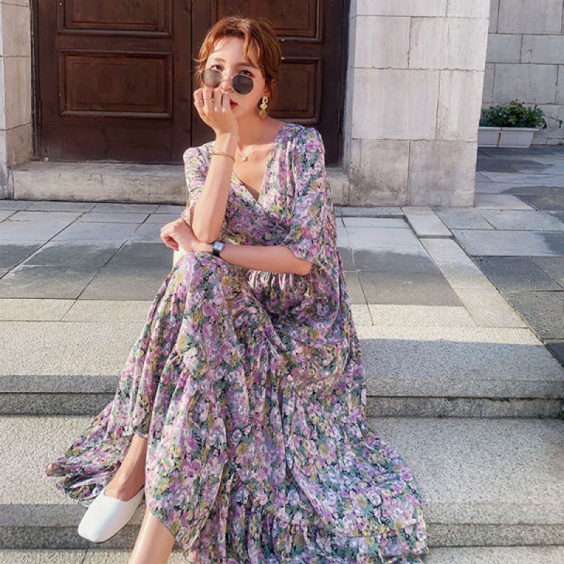 Woman in a floral dress sitting on steps outdoors