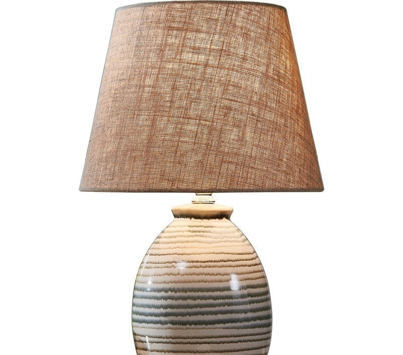 Table lamp with a textured brown shade and ceramic base on a white background