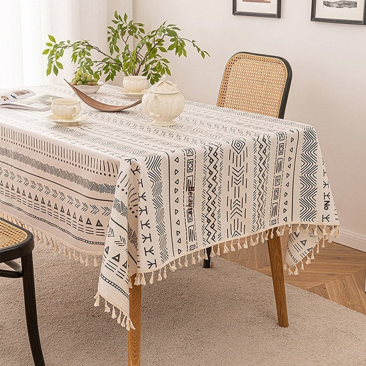 Tablecloth with geometric pattern on a dining table in a room with a plant and cabinet.