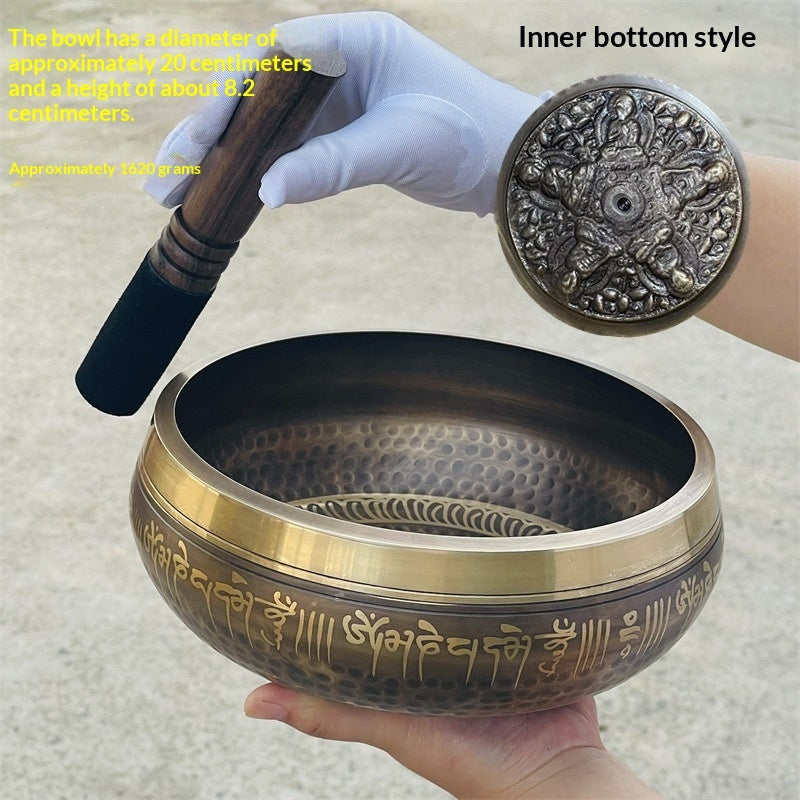 Tibetan singing bowl with decorative inner bottom style, held by a gloved hand.