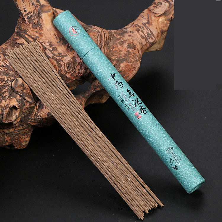 Turquoise incense box with incense sticks on a dark background